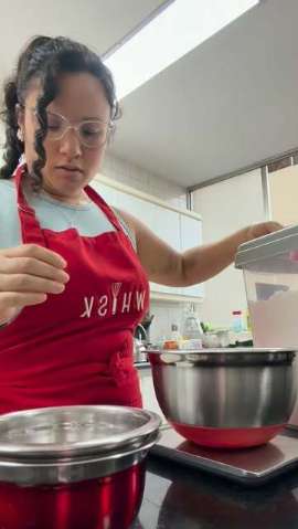Alicia Chong con mandil rojo de Whisk preparando buttercream